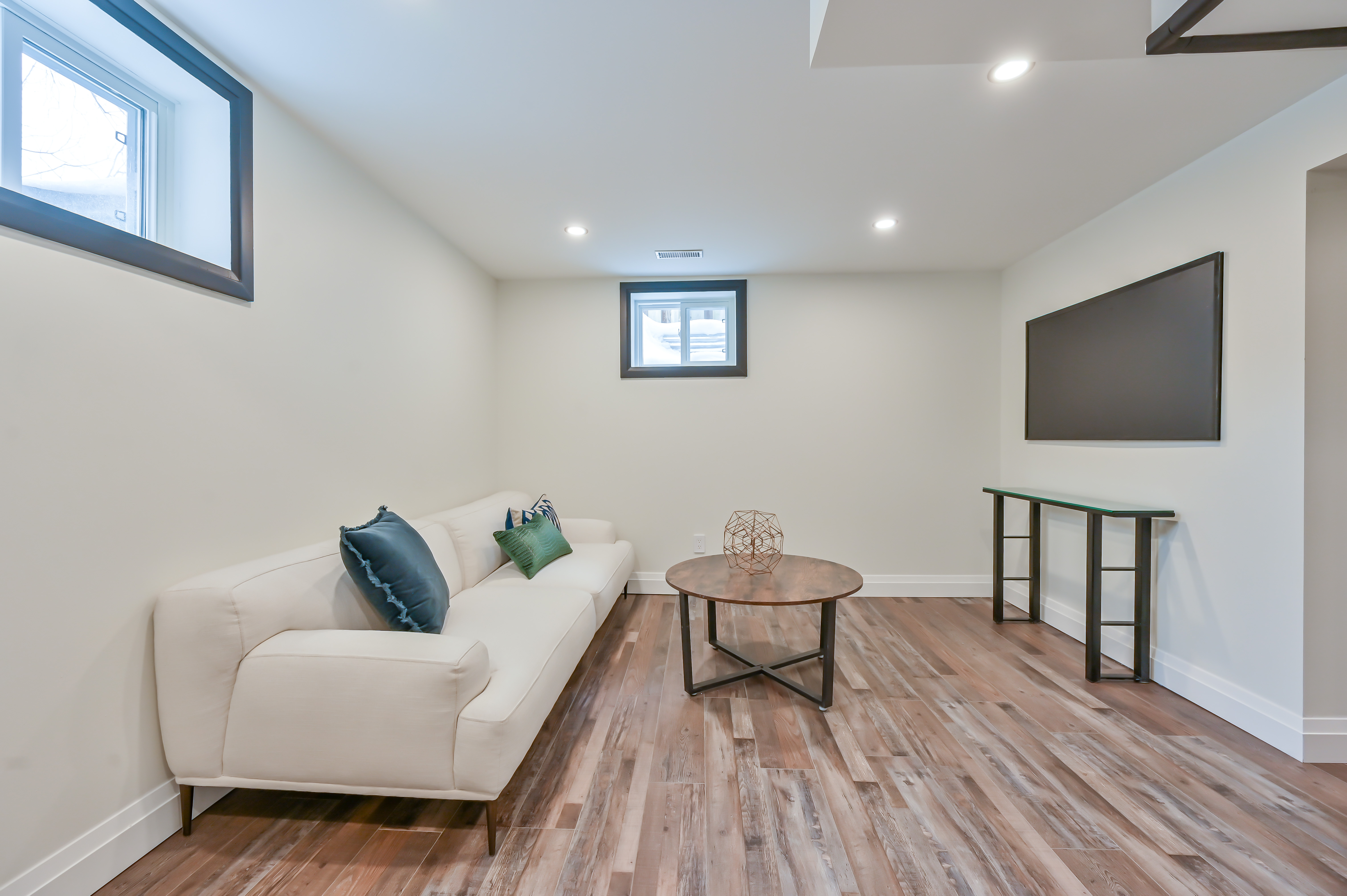 Bright finished basement with beautiful wood flooring and professional staging — premium portfolio shot — Kron, Hamilton | MTC Renovations